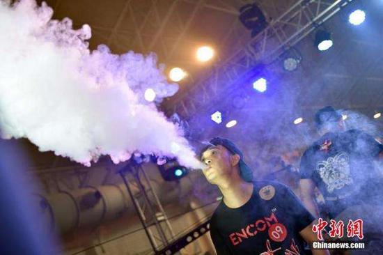 A man blows smoke with an electronic cigarette. (File photo/China News Service)