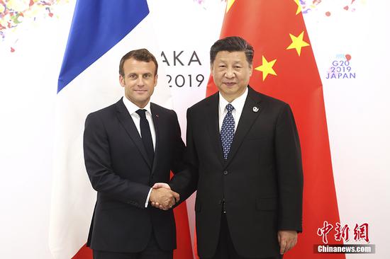 Chinese President Xi Jinping meets with his French counterpart, Emmanuel Macron, on the sidelines of a summit of Group of 20 major economies in the Japanese city of Osaka, June 29, 2019. (Photo/China News Service)