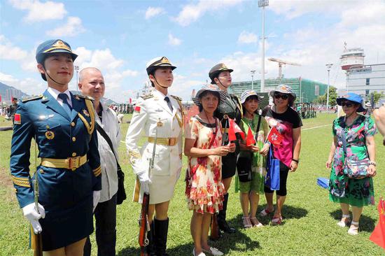 Civilians pose for photos with female service members during an event hosted by the People's Liberation Army Hong Kong Garrison on Monday. The two-­day event, which began on Sunday, is part of celebrations marking Hong Kong's return 22 years ago. (Photo: China News Service/Hong Shaokui)