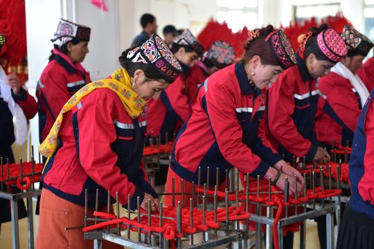 Women make Chinese knots at Tati Kuli, a settlement in Tashikurgan Tajik autonomous county, Xinjiang. (Photo by LIU YUHANG/FOR CHINA DAILY)