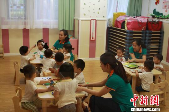 Teachers take care of children at a nursing center in Shanghai. (File photo/ China News Service)