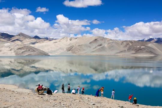 Tourists enjoy views of Baisha Lake, surrounded by snow-covered mountains on the Pamir Plateau in Akto county, Xinjiang Uygur autonomous region. （Photo/Xinhua）