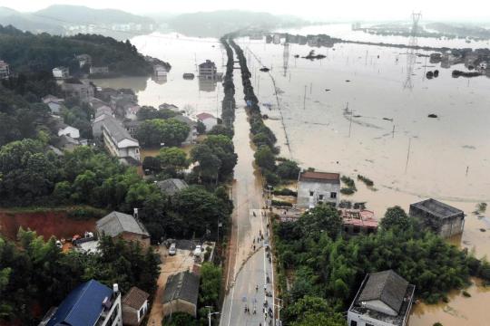 A main road leading to Hengdong county, Hunan province, was submerged by floodwaters on Thursday. The levee of a nearby river had two bursts of about 50 and 30 meters on Wednesday, leaving several villages soaked. (YANG HUAFENG/FOR CHINA DAILY)