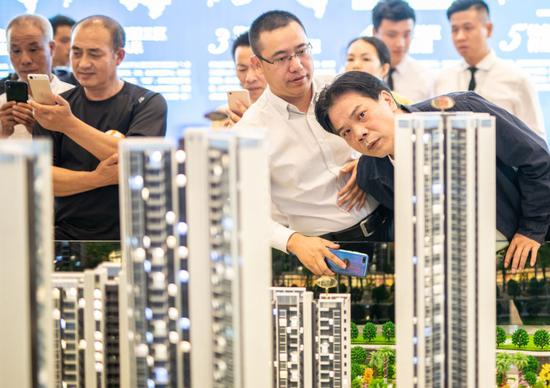 Potential homebuyers check out housing projects at a sales outlet in Dongguan, Guangdong province. [Photo by An Dong/For China Daily]
