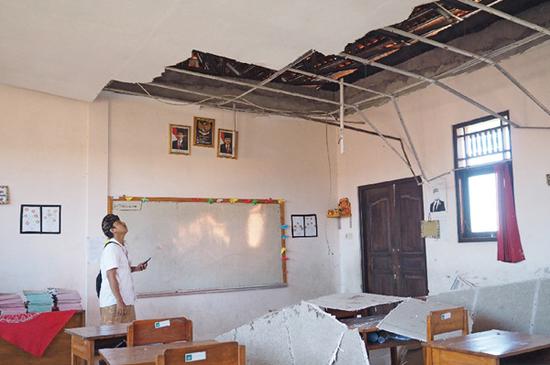 An elementary school teacher examines a damaged classroom after an earthquake in Nusa Dua, Bali, Indonesia, July 16, 2019. An earthquake of 6.0 magnitude struck off Indonesia's Bali Island earlier on Tuesday but there was no potential for tsunami, the meteorology and geophysics agency said. (Xinhua/Monstar Simanjuntak)