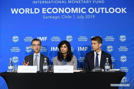 Gita Gopinath (C), IMF chief economist, and Gian Maria Milesi-Ferretti (L), the IMF's deputy director for research, attend a press conference in Santiago, Chile, July 23, 2019. The International Monetary Fund (IMF) lowered its global growth forecast to 3.2 percent in 2019, according to a report released here on Tuesday. (Xinhua/Jorge Villegas)