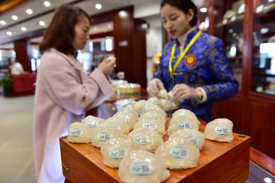 A customer purchases imported bird's nest from Indonesia at an expo in Yiwu, Zhejiang province. (Photo by Lyu Bin/For China Daily)
