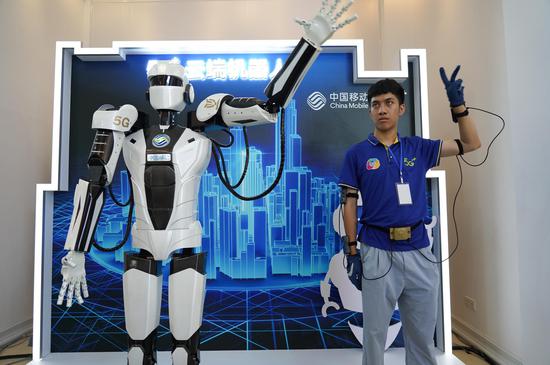 A man controls a robot with 5G technology during Jiangxi International Mobile Internet of Things Expo 2019 in Yingtan, east China's Jiangxi Province, July 18, 2019. (Xinhua/Zhou Mi)