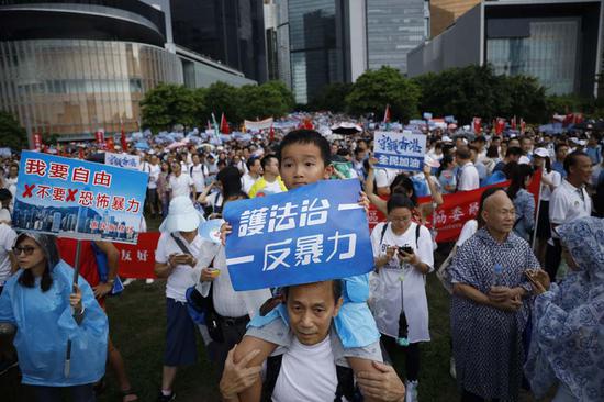 A boy holds a placard that reads 