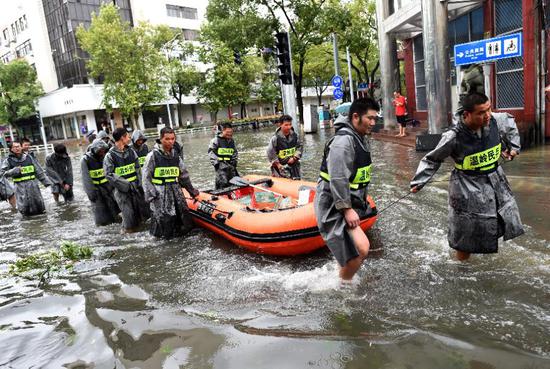 Staff members transport relief supplies via a rubber dinghy in Wenling, east China's Zhejiang Province, Aug. 10, 2019. (Xinhua/Han Chuanhao)