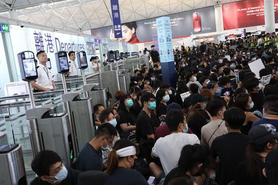 Protesters clog the departure area of Hong Kong International Airport in the evening of Aug 13, 2019. (Photo/CHINA DAILY)