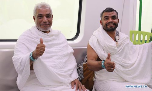 Two pilgrims give thumbs up to the fast and convenient services of the Meacca light rail trains in Mecca, Saudi Arabia, Aug. 11, 2019. (Photo by Dong Liwei/Xinhua)