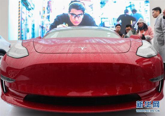 Visitors look at a Tesla Model 3 car in Shanghai, Jan. 7, 2019. （File photo/Xinhua） 