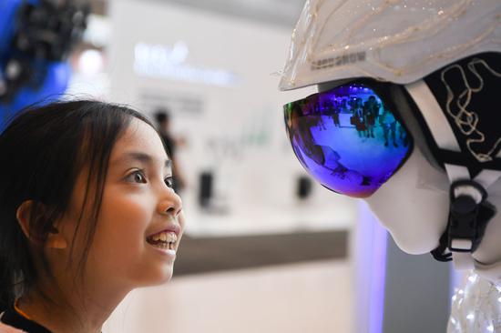 A child gets a preview of an automaton at the venue of the 2019 Smart China Expo in Chongqing on Sunday. The four-day expo opened on Monday. [Photo/Xinhua] 