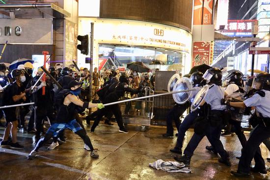 Radical protesters attack police officers in Tsuen Wan, in the western New Territories of south China's Hong Kong, Aug. 25, 2019. Radical protesters block various roads, hurl bricks and stones at police officers in the protest. (Xinhua/Lui Siu Wai)