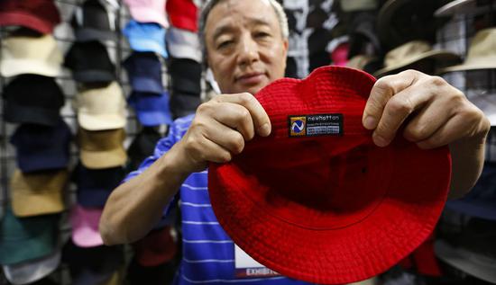 An exhibitor shows a hat made in China at the Offprice Show in Las Vegas, the United States, Aug. 11, 2019. (Xinhua/Li Ying)