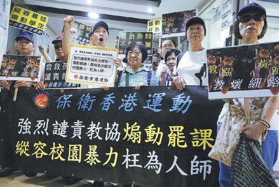 Members of the Defend Hong Kong Campaign protest against the Hong Kong Professional Teachers' Union's call for a strike at the office of the teachers' union in Hong Kong on Wednesday. (Photo/CHINA DAILY)