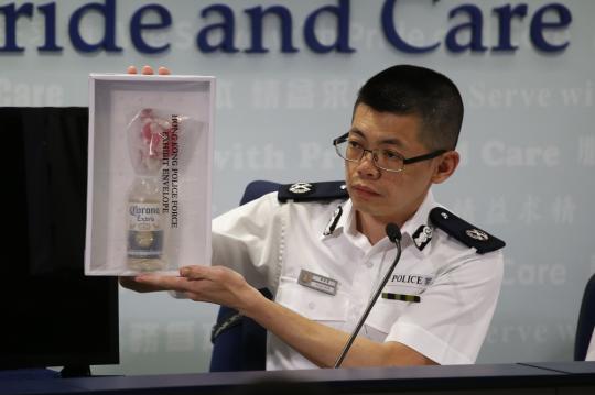 Mak Chin-ho, assistant commissioner of police operations in Hong Kong, displays a gasoline bomb confiscated during the weekend's unauthorized assemblies, at a news conference at police headquarters in Wan Chai on Monday. (Photo/CHINA DAILY)