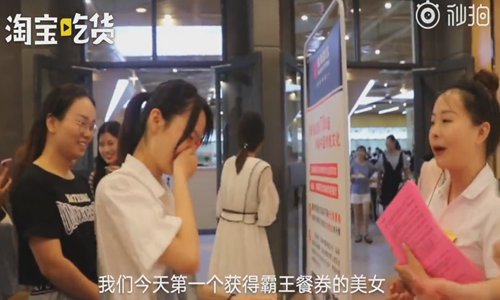 Students line up at the entrance of a cafeteria at the Henan Normal University in Xinxiang, Central China's Henan Province for their chance to wear a discount coupon for correctly reciting a traditional Chinese poem chosen at random. (Photo/Screenshot from video posted by Taobao Chi Huo)
