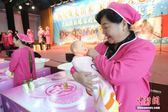 A home-service worker learns to take care of a baby at a domestic company in Gansu. (File photo/China News Service)