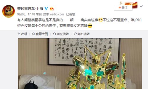 Japanese toymaker Bandai gives a limited edition gold plated Unicorn Gundam figure to the Shanghai police after they busted a 300 million yuan ($42 million) counterfeit case. (Photo/Screenshot from the Sina Weibo account of Shanghai police)