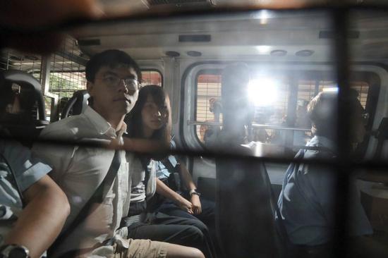 oshua Wong Chi-fung and Agnes Chow Ting are escorted in a police vehicle to the Eastern Magistrates' Court for a court appearance on the afternoon of Aug 30, 2019, after they were arrested in the morning the same day. (Photo/China Daily)