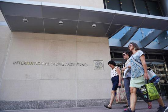 People walk past the headquarters of the International Monetary Fund (IMF) in Washington D.C., the United States, on Aug. 9, 2019. (Xinhua/Liu Jie)