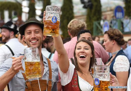 People drink beer in a festival tent during the first day of the Oktoberfest 2019 in Munich, Germany, Sept. 21, 2019. The 186th Oktoberfest, one of the world's largest folk festivals, officially opened here on Saturday. It is expected that around 6 million visitors from all over the world will enjoy festival beer and culinary delicacies here from Sept. 21 to Oct. 6. (Xinhua/Lu Yang)