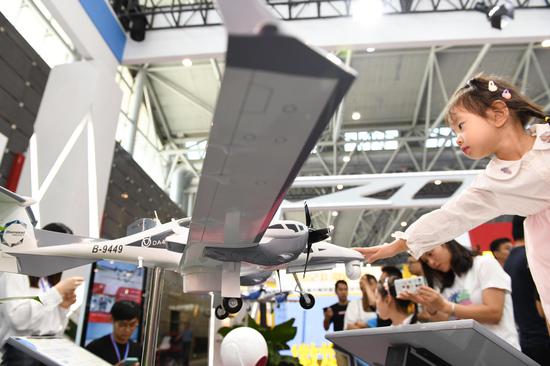 A child looks at a displayed aeroplane model from CETC Wuhu Diamond Aircraft Manufacture Co., Ltd. during the 2019 World Manufacturing Convention in Hefei, east China's Anhui Province, Sept. 22, 2019. (Xinhua/Liu Junxi)