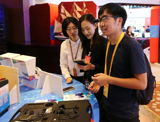 Reporters visit the digital media experience lab at the news center for the 70th anniversary of the People's Republic of China. The center opened in Beijing on Monday. (China Daily/Wang Zhuangfei)