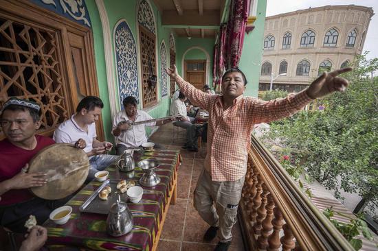 A local resident dances to the music at a tea house in the ancient city of Kashgar, northwest China's Xinjiang Uygur Autonomous Region, July 7, 2019. (Xinhua/Zhao Ge)