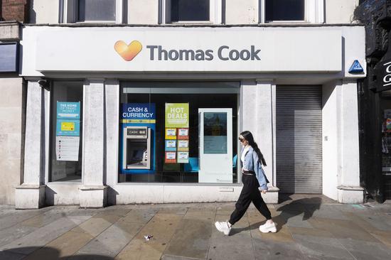 A woman walks past a closed Thomas Cook store in London, Britain, on Sept. 23, 2019. British travel giant Thomas Cook on Monday announced its collapse after failed rescue attempts, leaving about 21,000 jobs worldwide at risk. (Photo by Ray Tang/Xinhua)