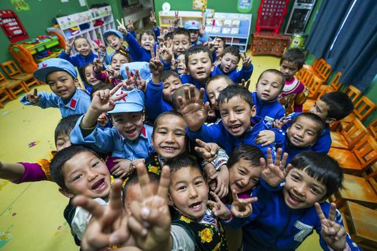 Children pose for a photo at a kindergarten at Liangzhongchang Village in Yutian County of Hotan, northwest China's Xinjiang Uygur Autonomous Region, Feb. 13, 2019. (Xinhua/Zhao Ge)