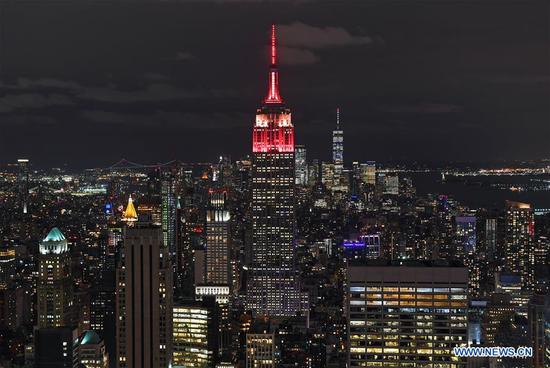 The top of the New York City's landmark Empire State Building (C) is lit up red and yellow in celebration of the 70th anniversary of the founding of the People's Republic of China (PRC) in New York City, the United States, on Sept. 30, 2019. New York City's landmark Empire State Building was lit with a light show on Monday night in celebration of the 70th anniversary of the founding of the People's Republic of China (PRC). The tower lighting also marks the 40th anniversary of the establishment of diplomatic relations between the United States and the PRC. (Xinhua/Li Rui)