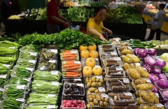 A customer selects vegetables at a supermarket in Wuxi City, east China's Jiangsu Province, June 12, 2019. (Xinhua/Huan Yueliang)
