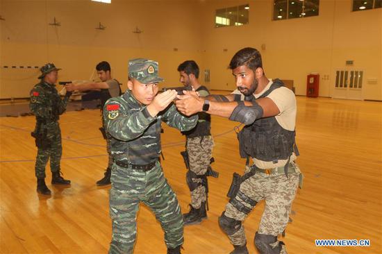 Chinese People's Armed Police Force (CAPF) training group members teach Kuwait National Guard (KNG) soldiers shooting tactics in a military camp in Farwaniya Governorate, Kuwait, on Sept. 19, 2019. In the past month, seven officers from the Chinese People's Armed Police Force (CAPF) trained Kuwait National Guard (KNG) soldiers in shooting and combat tactics. (Photo by Niu Yuxi/Xinhua)