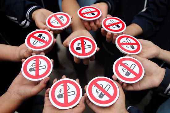 Middle school students hold cigarette models with no smoking signs during a World No Tobacco Day activity in Handan, north China's Hebei Province, May 29, 2015. (Xinhua/Mou Yu)