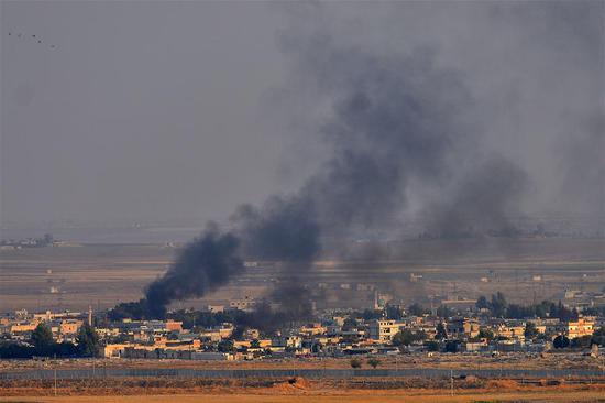 Photo taken from southern Turkish border town of Ceylanpinar on Oct. 10, 2019 shows smoke rising from the northern Syrian city of Ras al-Ain during an attack launched by Turkish army. (Photo by Mustafa Kaya/Xinhua)
