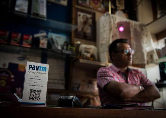 A shop owner collects payment with Paytm, an electronic payment sponsored by China's Ant Financial, in New Delhi, India, April 12, 2017. (Xinhua/Bi Xiaoyang)