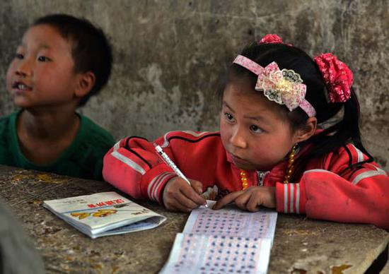 A girl attends a class at a rural school in Bijie, Guizhou Province. (Photo by Peng Nian/For China Daily)