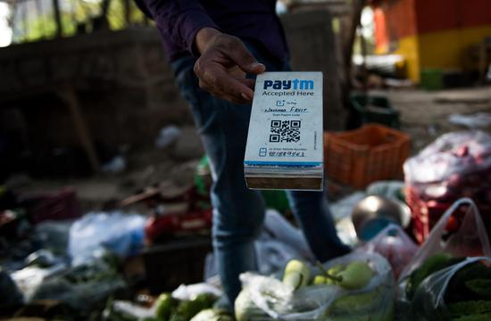A seller shows QR code to a customer to collect payment with Paytm, a payment app sponsored by Alipay's parent company Ant Financial, in New Delhi, India, April 12, 2017. (Xinhua/Bi Xiaoyang)