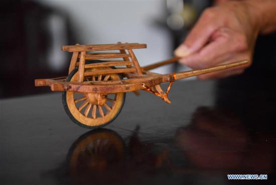 Carpenter makes wooden miniatures of farm tools