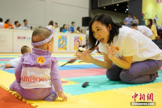 A nursery worker plays games with a baby. (File photo/China News Service)