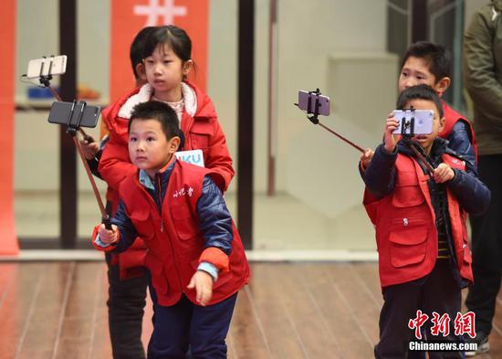 Children experience live-streaming at a sci-tech cultural event, Jan. 20, 2018. (File photo/China News Service)