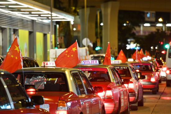 Taxis hanging Chinese national flags participate in a peace rally in Hong Kong on Aug. 23, 2019. Tse Ting-cheung also participated in the rally. (Xinhua)