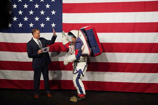 NASA Administrator Jim Bridenstine (L) welcomes Advanced Space Suit Engineer Kristine Davis, who wears the Exploration Extravehicular Mobility Unit (xEMU) spacesuit, at NASA headquarters in Washington D.C., the United States, on Oct. 15, 2019. (Xinhua/Liu Jie)
