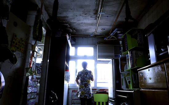 Wong, who prefers going by an alias, stands in her 37-square-meter public rental house in Choi Hung, Kowloon of south China's Hong Kong, Sept. 17, 2019. (Xinhua/Luo Huanhuan)