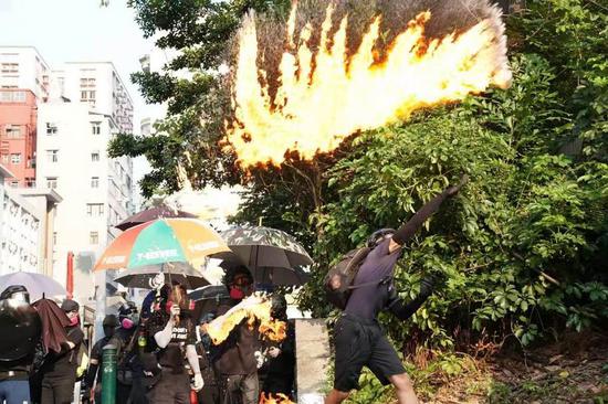 Rioters throw petrol bombs near the Tsim Sha Tsui police station in Hong Kong, south China, Oct. 20, 2019. (Xinhua)