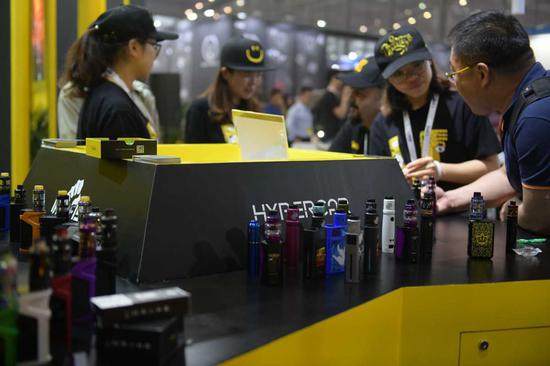 A visitor checks out an e-cigarette during an exhibition in Shenzhen, Guangdong Province.(Photo provided to China Daily)