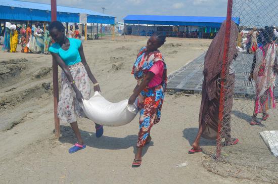 People carry food rations donated by the World Food Program (WFP) at the Malakal Protection of Civilians site in Malakal, South Sudan, June 19, 2019. (Photo by Denis Elamu/Xinhua)